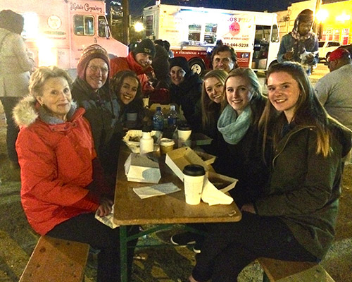 Family and friends finding a warm spot next to the fire pit on a chilly winter evening.